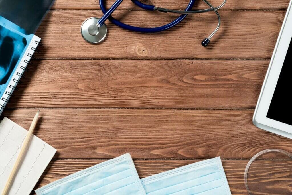 Echipamente medicale pe masă din lemn, stetoscop, măști.