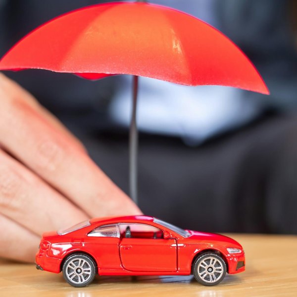 Mașină roșie jucărie sub umbrelă roșie